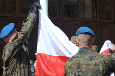 Dwóch żołnierzy Wojska Polskiego wiesza flagę RP na maszcie